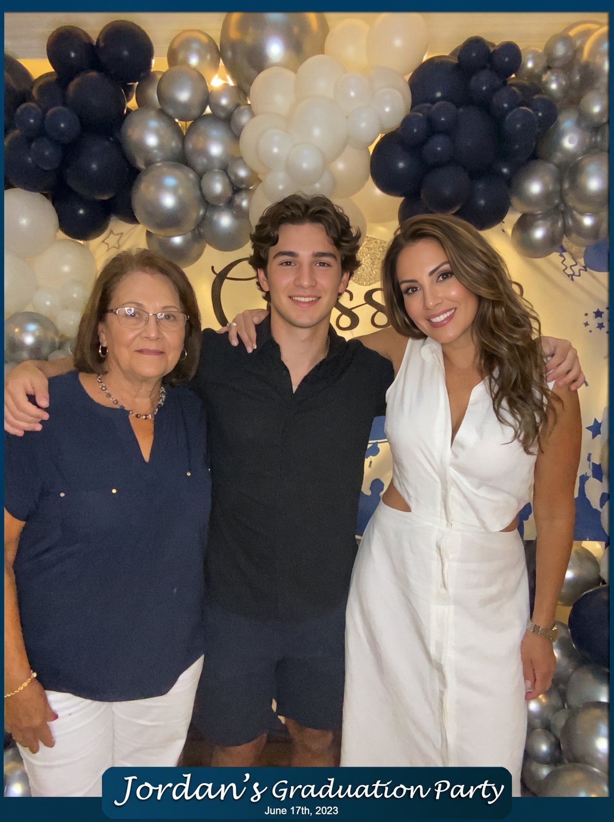 Three family members in front of a navy, silver and white balloon arch, with a Jordan's Graduation Party overlay